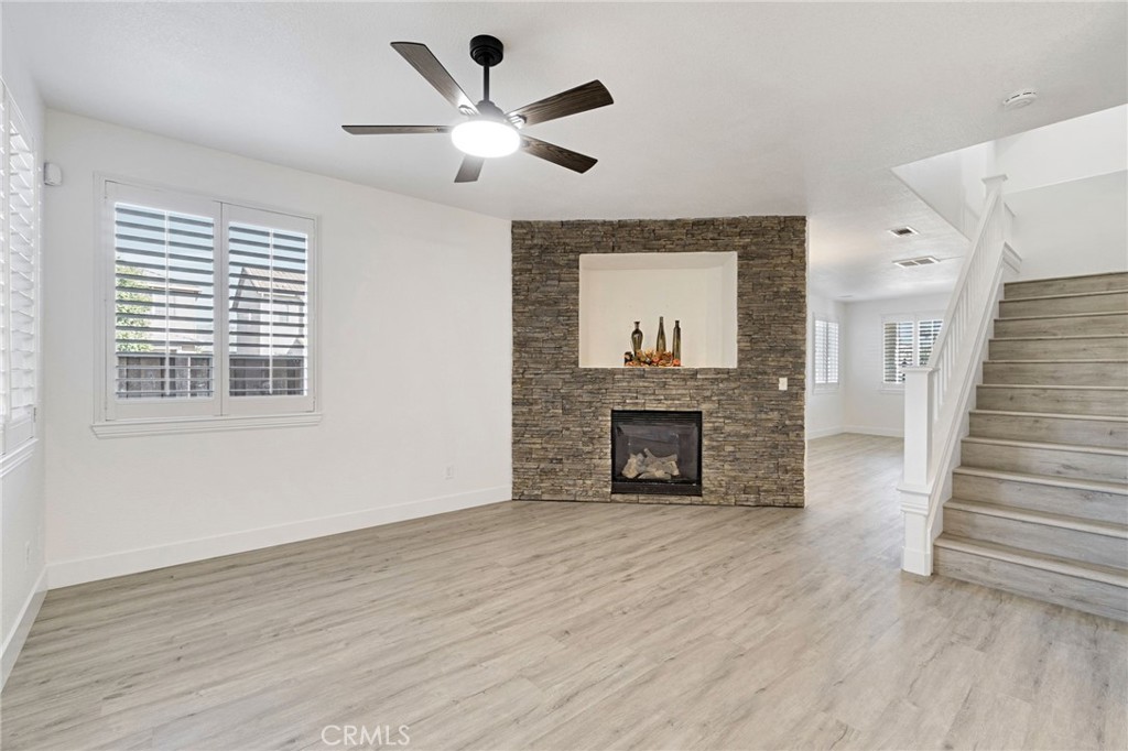 692 Blueberry Lane Madera, CA 93638 - Photo 9 of 44 an empty room with wooden floor fireplace and windows