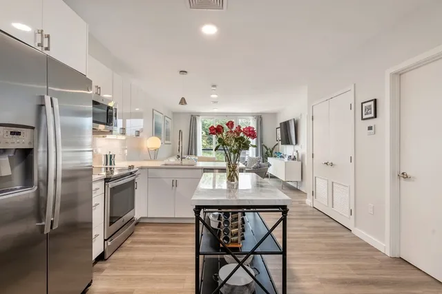 a kitchen with kitchen island a counter top space cabinets and stainless steel appliances