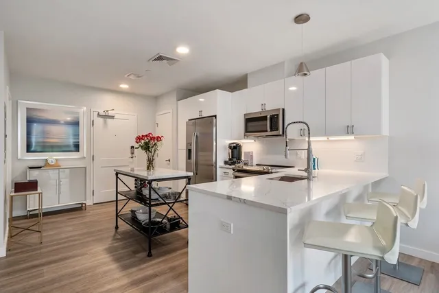 a kitchen with a dining table chairs and refrigerator