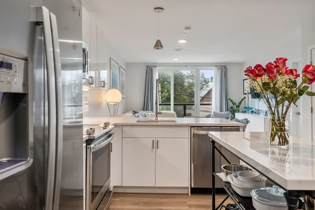 a kitchen with stainless steel appliances granite countertop a sink refrigerator and cabinets
