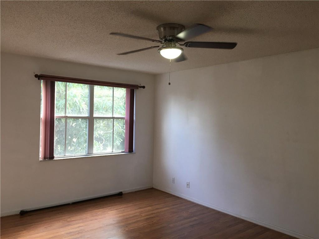 8422 Southwest 44th Place Davie, FL 33328 - Photo 9 of 16 an empty room with wooden floor chandelier fan and windows