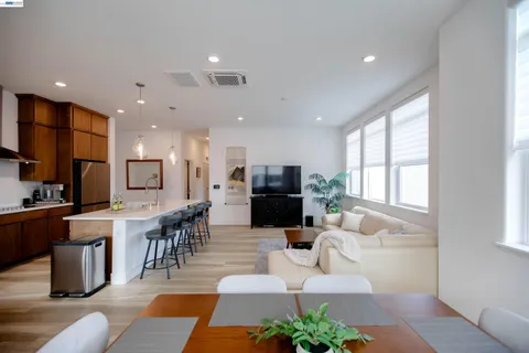 a living room with furniture kitchen view and a large window