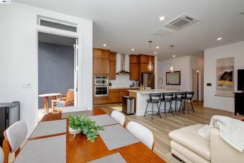 a living room with furniture and a dining table with kitchen view