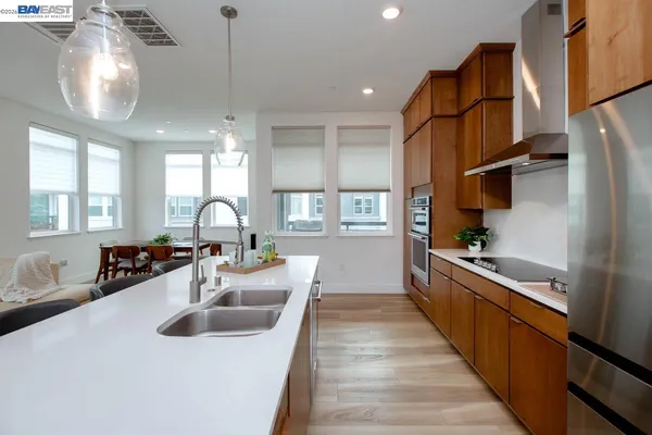 a kitchen with kitchen island granite countertop a sink cabinets and stainless steel appliances
