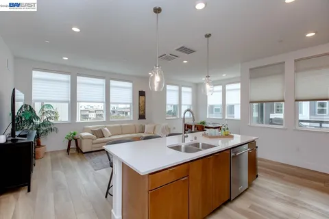 a view of a kitchen counter top space with a sink wooden floor and windows