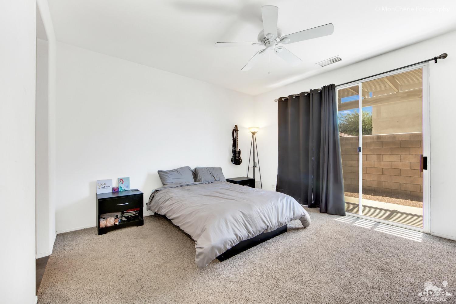 82903 Corte Lucia Indio, CA 92201 - Photo 12 of 26 a bedroom with a bed and a chandelier