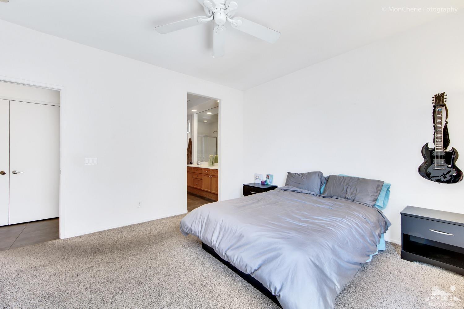 82903 Corte Lucia Indio, CA 92201 - Photo 13 of 26 a bedroom with a bed and a chandelier