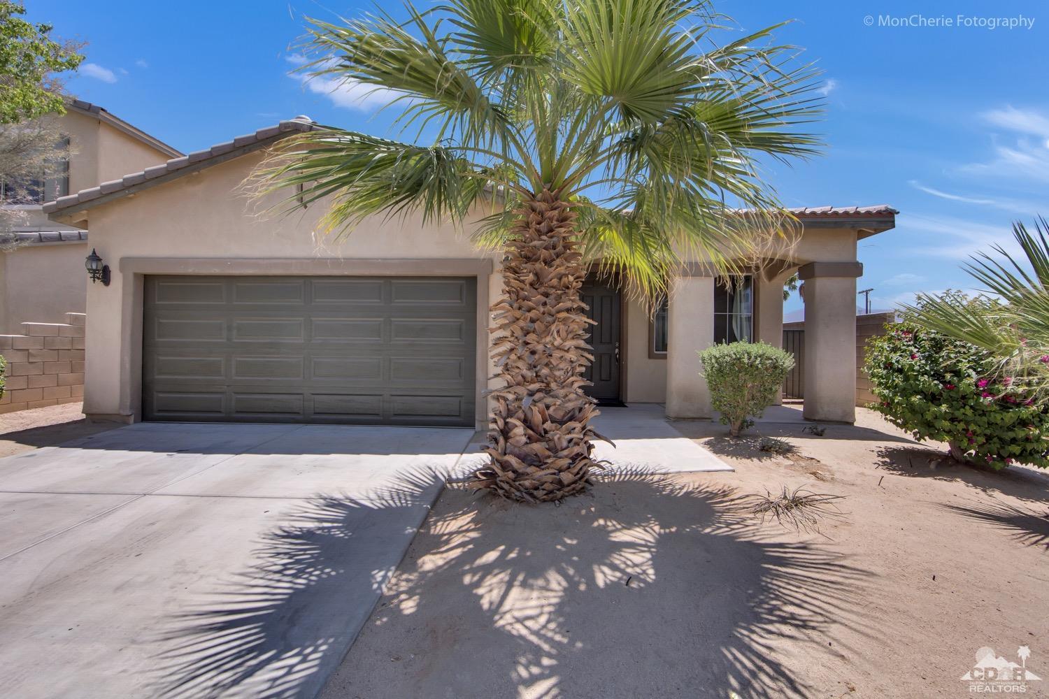82903 Corte Lucia Indio, CA 92201 - Photo 23 of 26 a front view of house with yard and yellow lighting