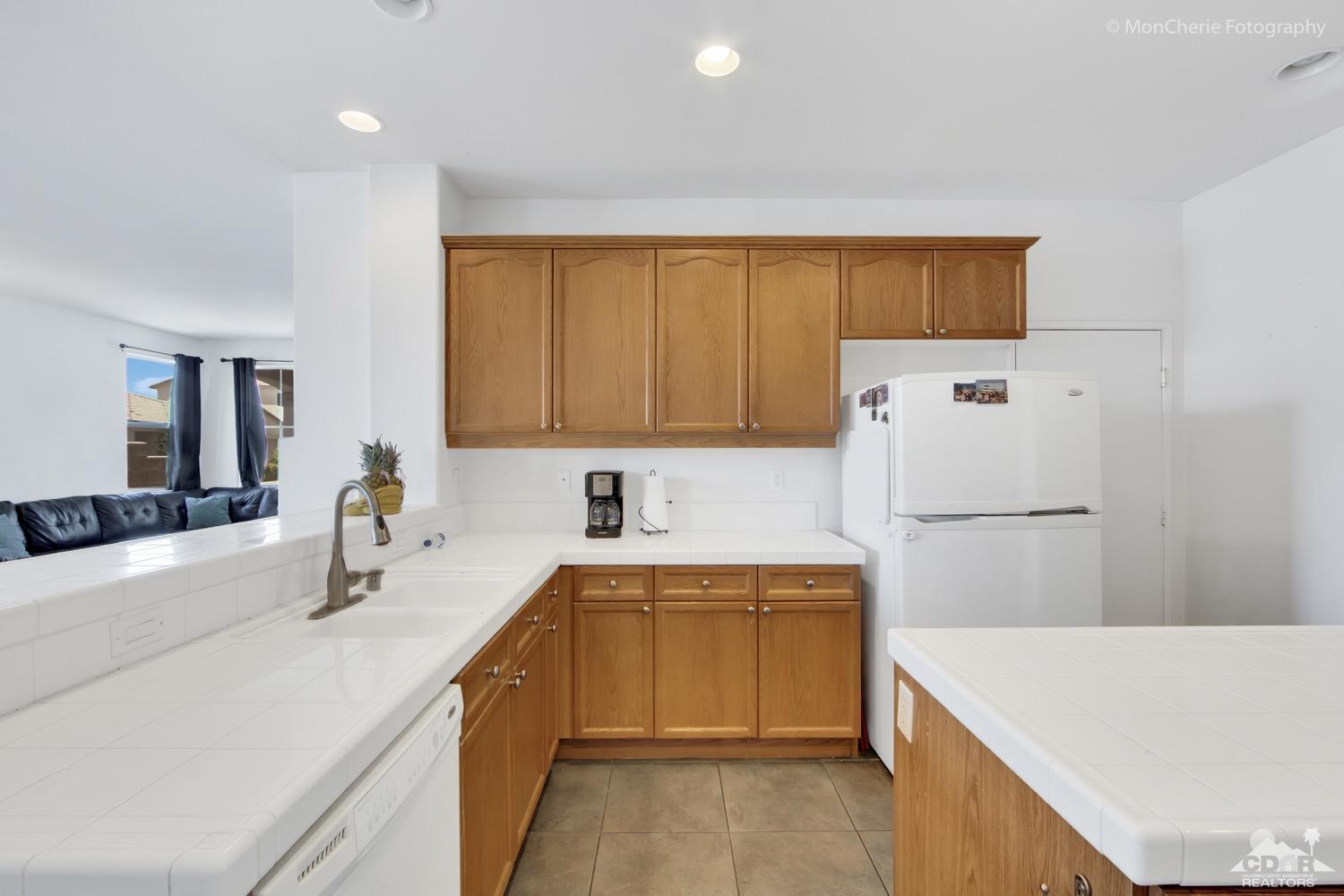 82903 Corte Lucia Indio, CA 92201 - Photo 9 of 26 a kitchen with a sink a refrigerator and white cabinets