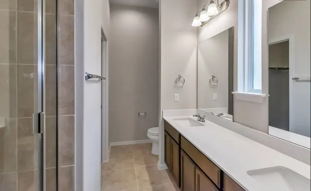 a bathroom with a sink vanity granite shower and a mirror