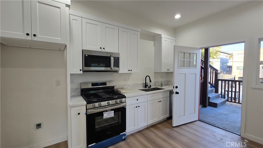1036 Beacon Avenue, Unit 1036 Los Angeles, CA 90015 - Photo 6 of 7 a kitchen with a sink stove and cabinets