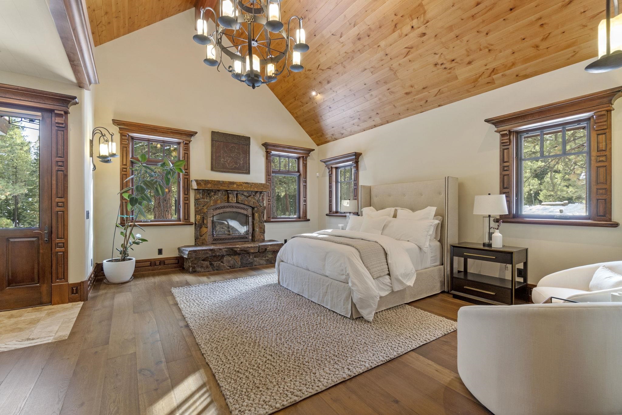 12541 Granite Drive Truckee, CA 96161 - Photo 10 of 20 a spacious bedroom with a large bed a flat tv screen and a fireplace with wooden floor