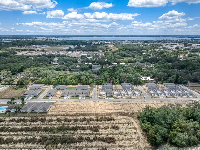 a view of a big house with a big yard and potted plants