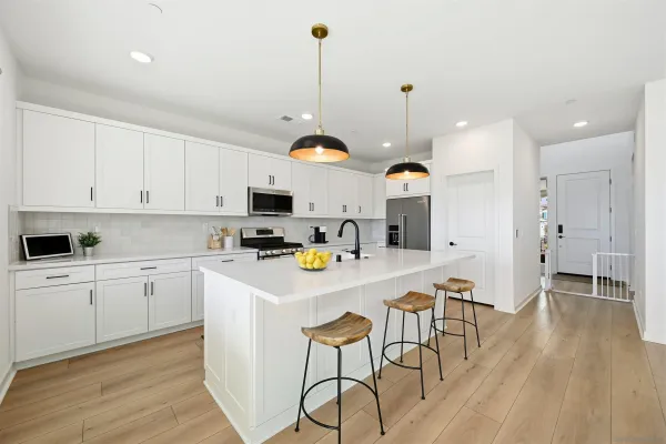a kitchen with kitchen island white cabinets and stainless steel appliances