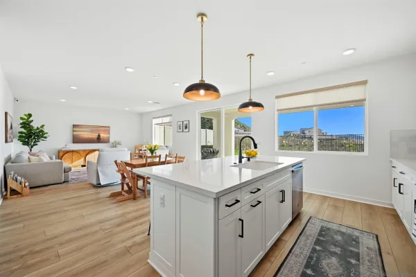 a large kitchen with stainless steel appliances kitchen island granite countertop a sink a stove and a wooden floors