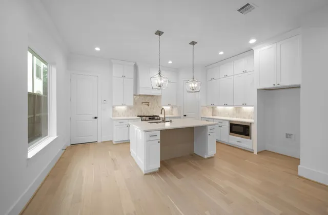 a kitchen with a refrigerator sink and cabinets