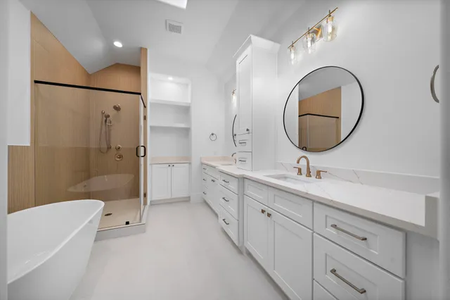 a bathroom with a double vanity sink mirror and shower