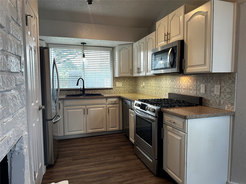 504 Suzzane Road Pflugerville, TX 78660 - Photo 9 of 15 a kitchen with stainless steel appliances granite countertop a sink and a stove top oven