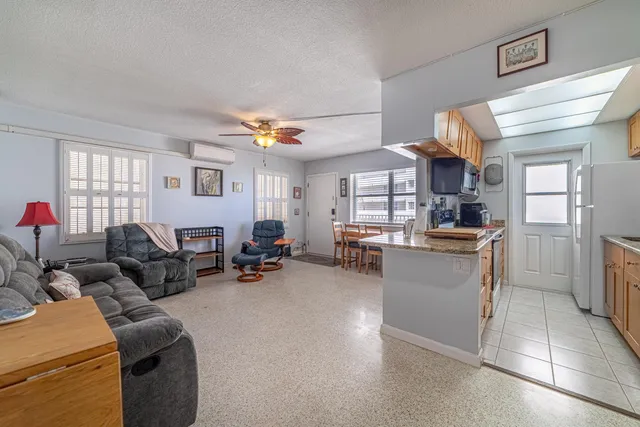 a living room with furniture and a kitchen area