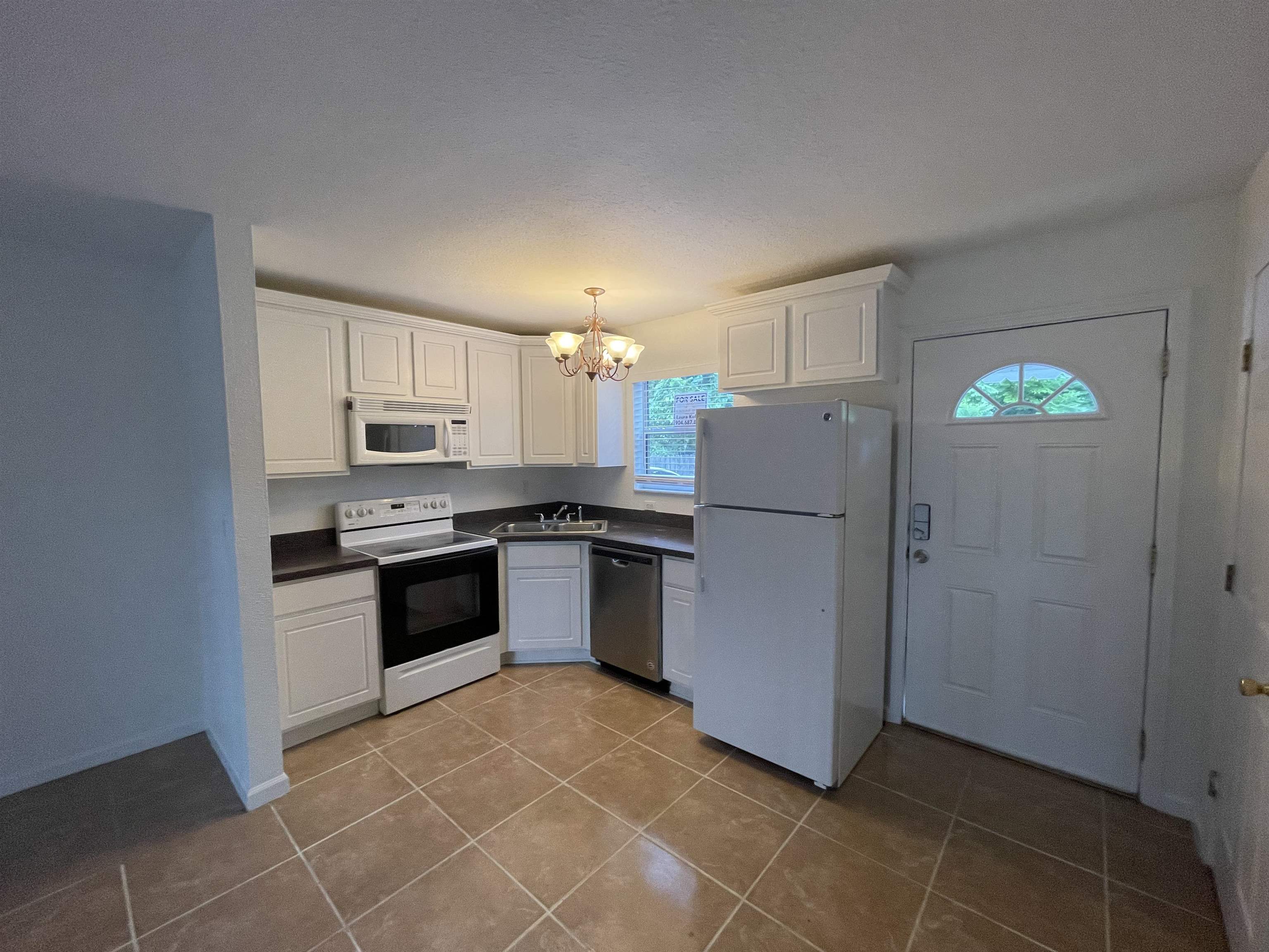 4420 Carter Road, Unit 60 St. Augustine, FL 32086 - Photo 2 of 14 a kitchen with a refrigerator a stove top oven and white cabinets