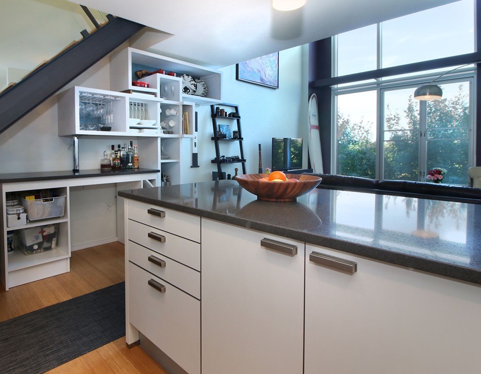a kitchen with stainless steel appliances white cabinets and a large window
