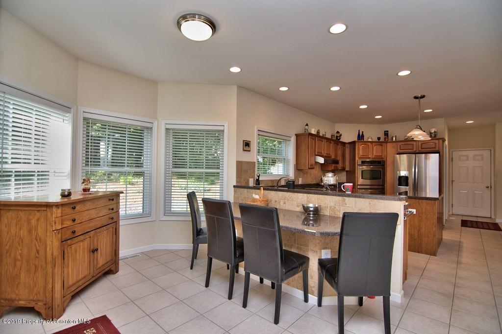 801 Forest Road Lake Ariel, PA 18436 - Photo 11 of 54 a dining hall with stainless steel appliances kitchen island granite countertop a table and chairs