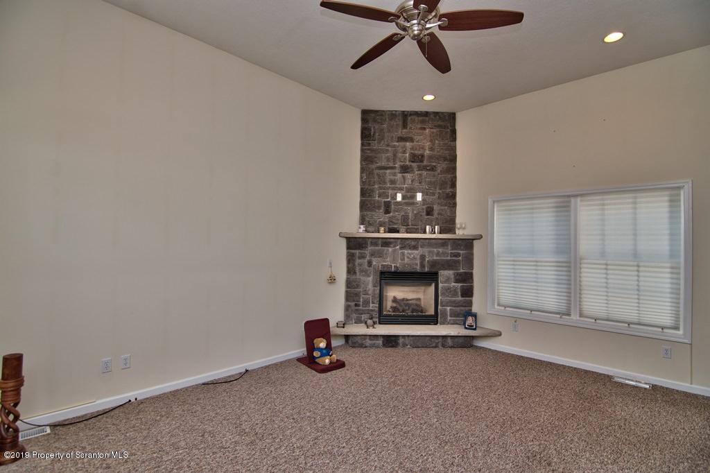 801 Forest Road Lake Ariel, PA 18436 - Photo 17 of 54 an empty room with fireplace and fan