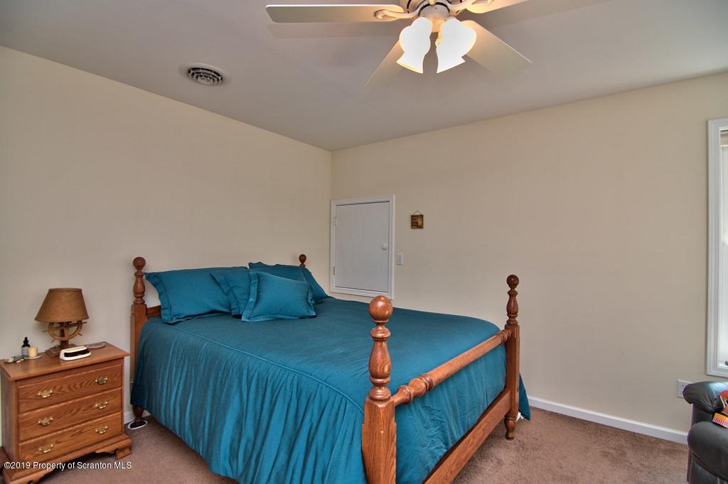 801 Forest Road Lake Ariel, PA 18436 - Photo 39 of 54 a bedroom with a bed and a chandelier