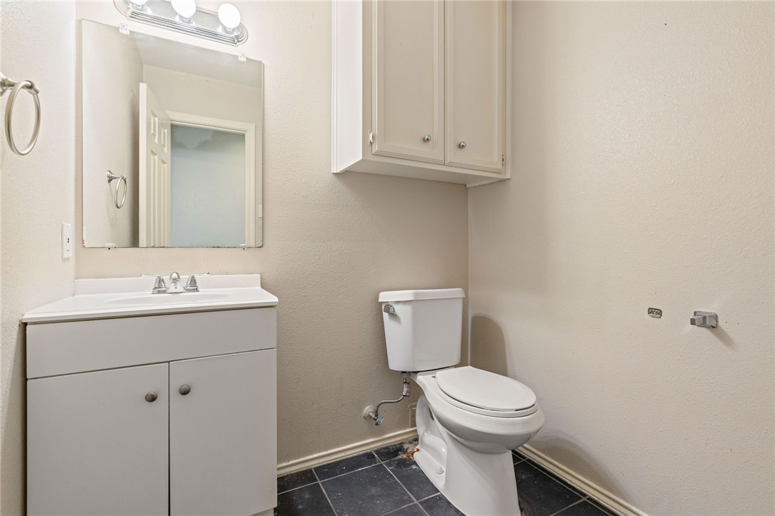 7209 Candy Ridge Road Corpus Christi, TX 78413 - Photo 17 of 24 a bathroom with a toilet a sink and mirror