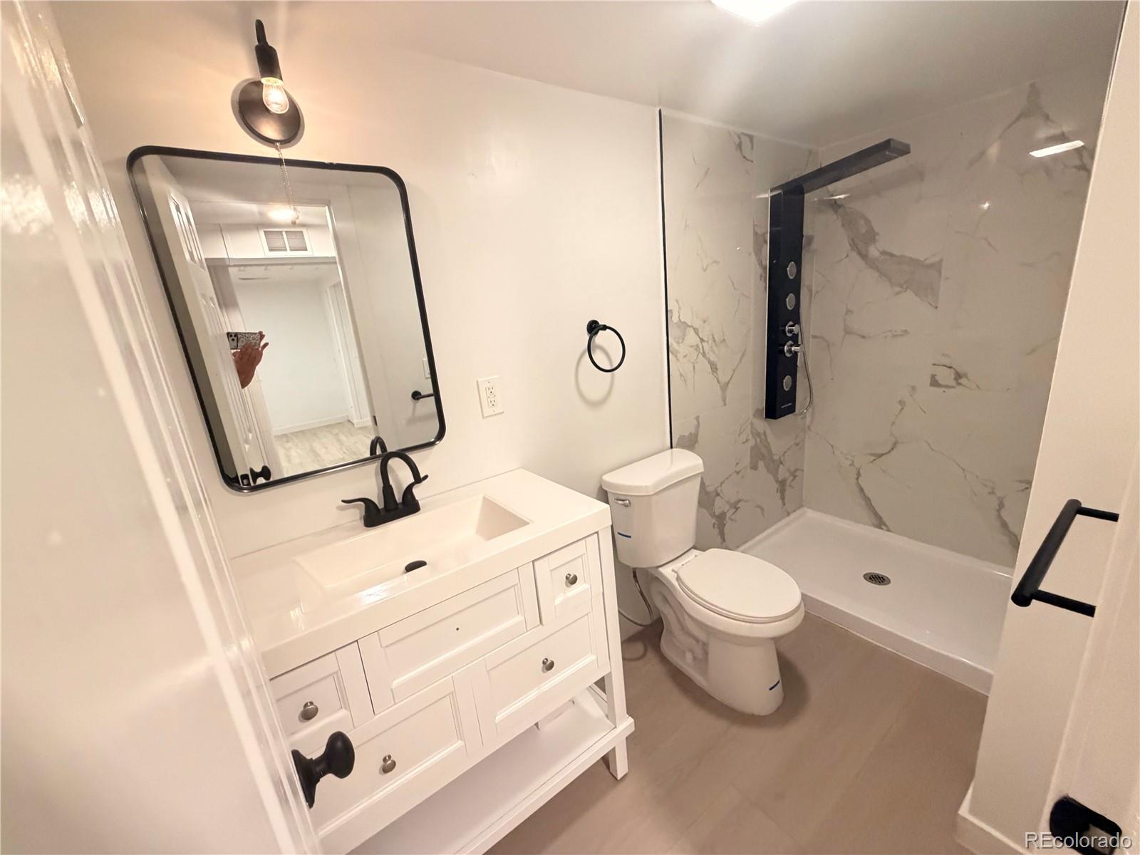 1173 Ironton Street Aurora, CO 80010 - Photo 21 of 28 a bathroom with a toilet sink and mirror