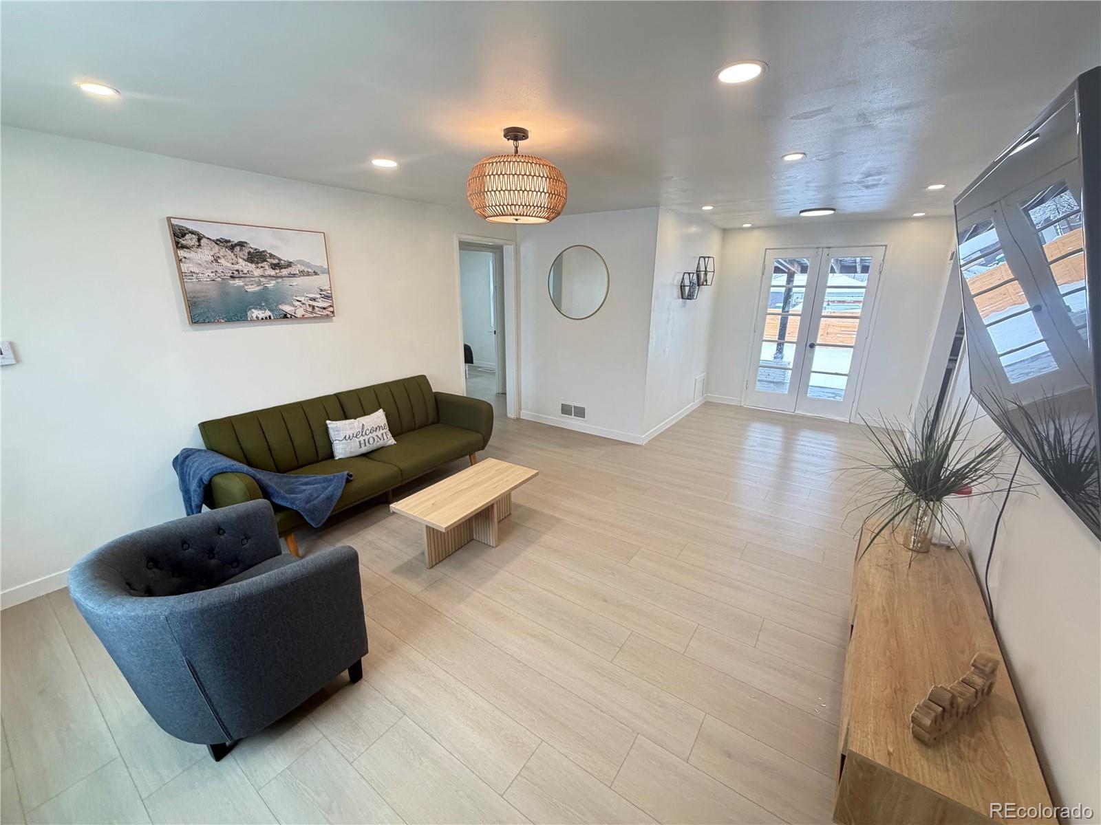 1173 Ironton Street Aurora, CO 80010 - Photo 6 of 28 a living room with furniture and a flat screen tv