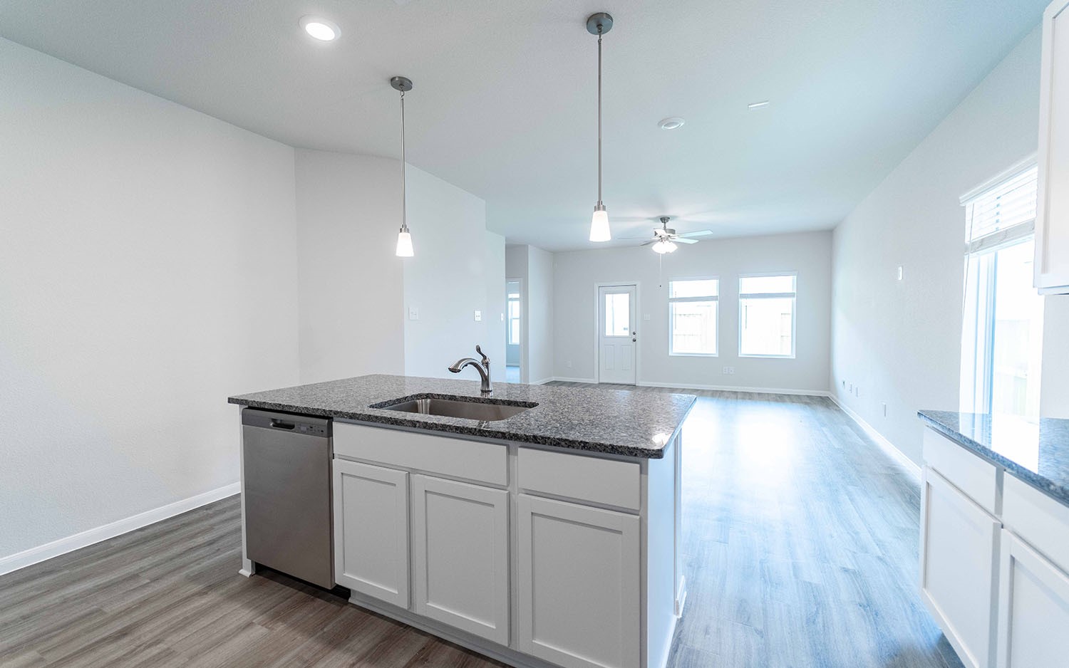 4326 Maple Root Lane Pinehurst, TX 77362 - Photo 11 of 27 a kitchen with granite countertop a sink a window and wooden floor