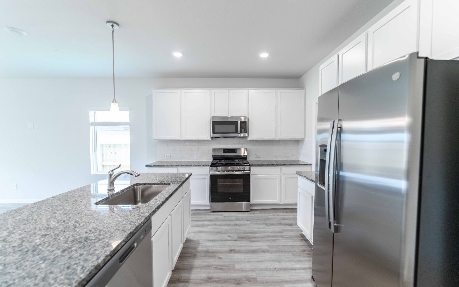 4326 Maple Root Lane Pinehurst, TX 77362 - Photo 7 of 27 a kitchen with stainless steel appliances granite countertop a refrigerator a sink a stove and oven