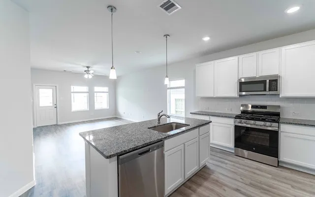 a kitchen with a sink stove and microwave