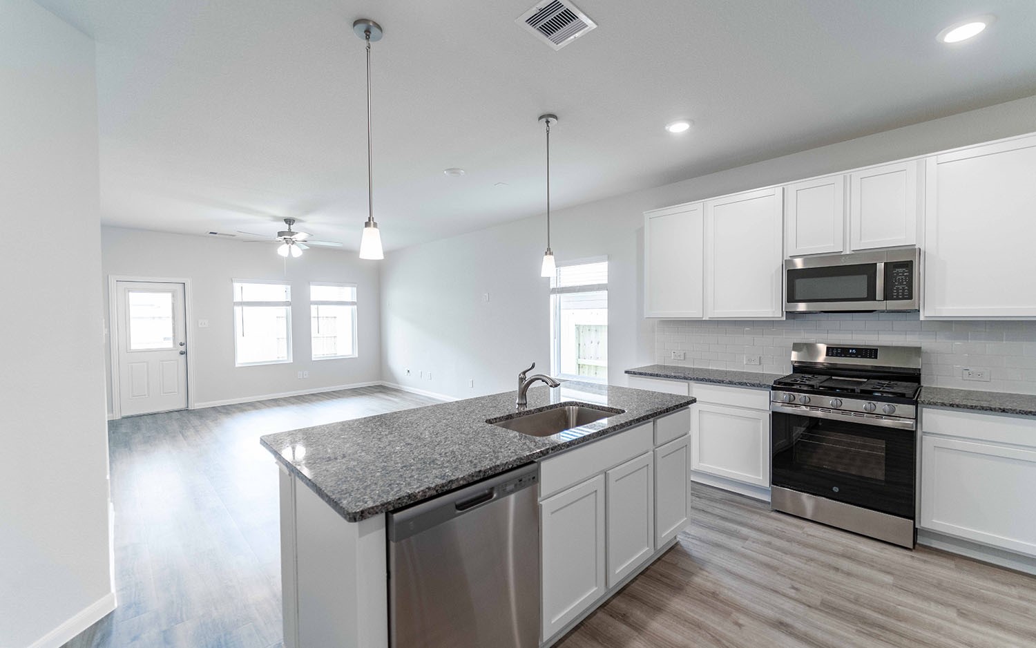 4326 Maple Root Lane Pinehurst, TX 77362 - Photo 8 of 27 a kitchen with a sink stove and microwave