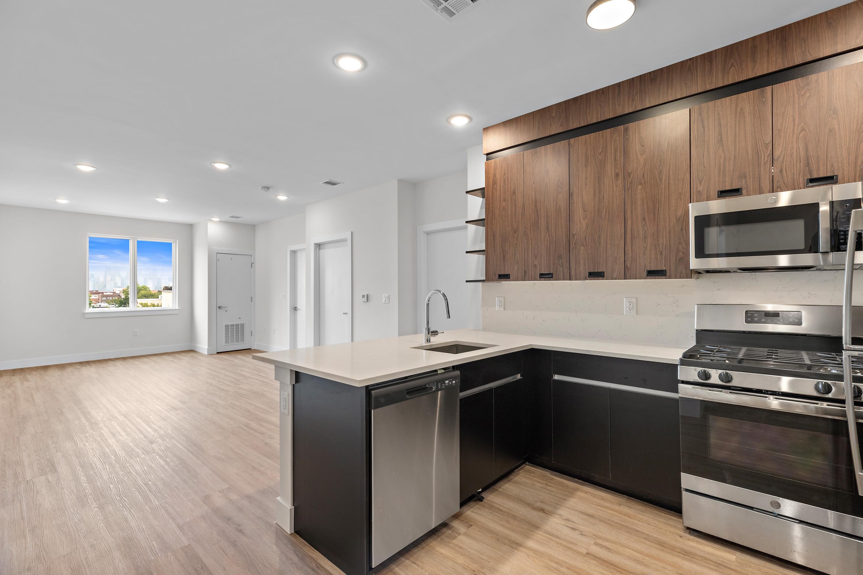 a kitchen with stainless steel appliances granite countertop a stove a sink and a microwave