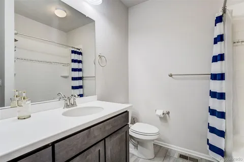 a bathroom with a shower sink vanity mirror and toilet