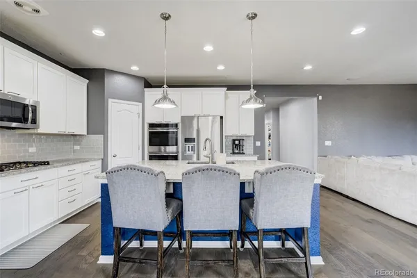 a kitchen with a center island and stainless steel appliances