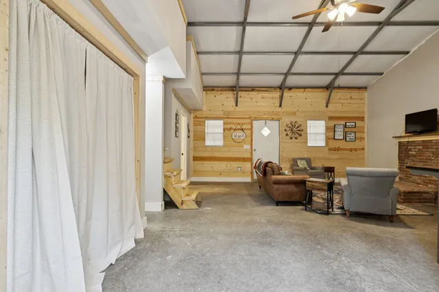 a living room with furniture a flat screen tv and a window