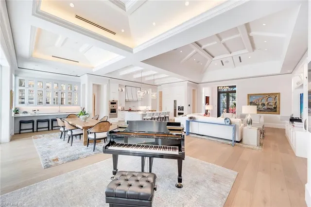 a living room with furniture a rug and kitchen view