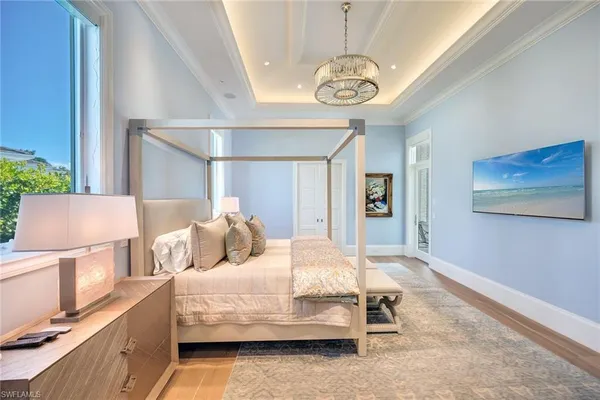 a bedroom with a bed and a chandelier