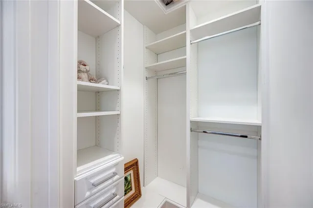 a view of walk in closet with empty racks