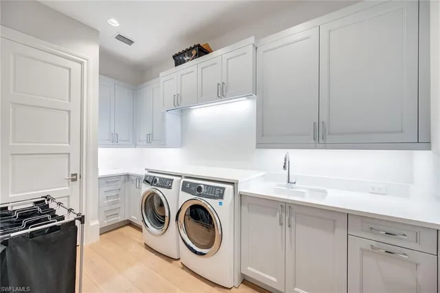 a utility room with sink dryer and washer