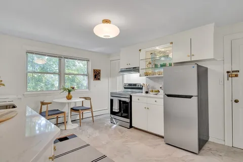 a kitchen with refrigerator cabinets and windows