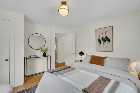 a bed room with a bed and a painting on the wall