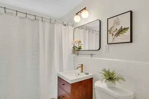 a bathroom with a sink a mirror and a shower curtain