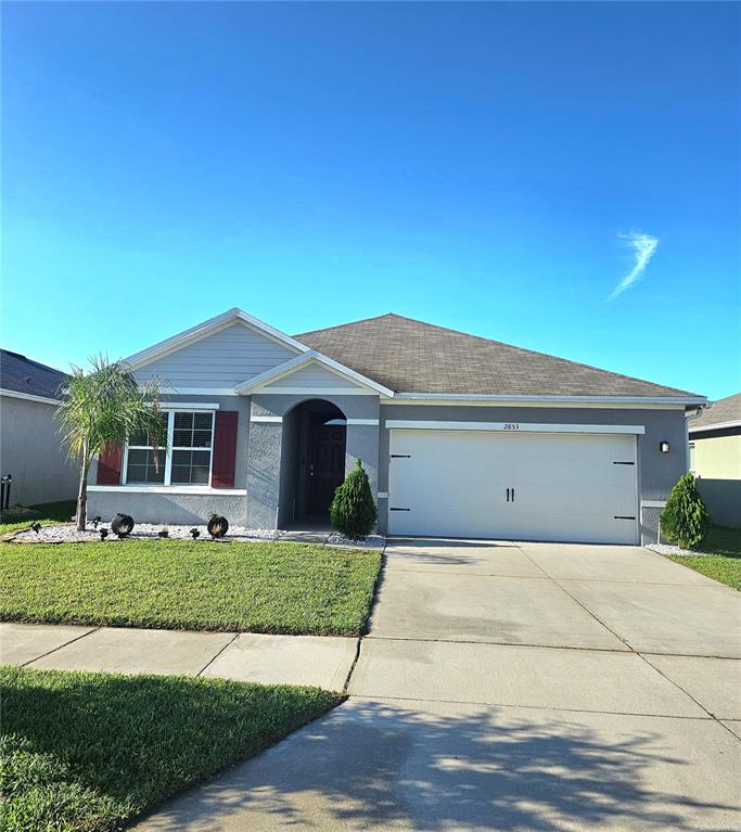 2853 Grandbury Grove Road Lakeland, FL 33811 - Photo 1 of 25 a front view of a house with a yard and garage