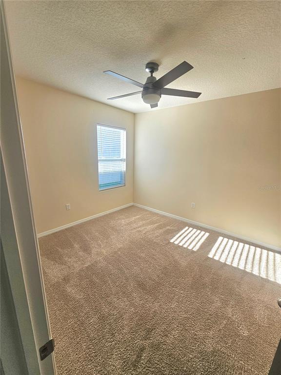 2853 Grandbury Grove Road Lakeland, FL 33811 - Photo 5 of 25 en empty room with windows and fan