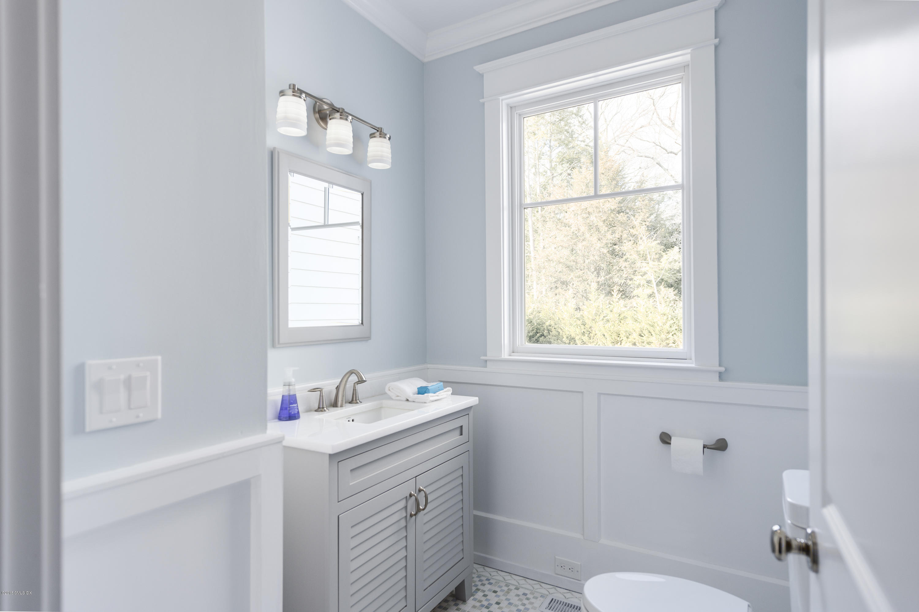121 Lockwood Road Riverside, CT 06878 - Photo 32 of 40 a bathroom with a window sink vanity and a toilet