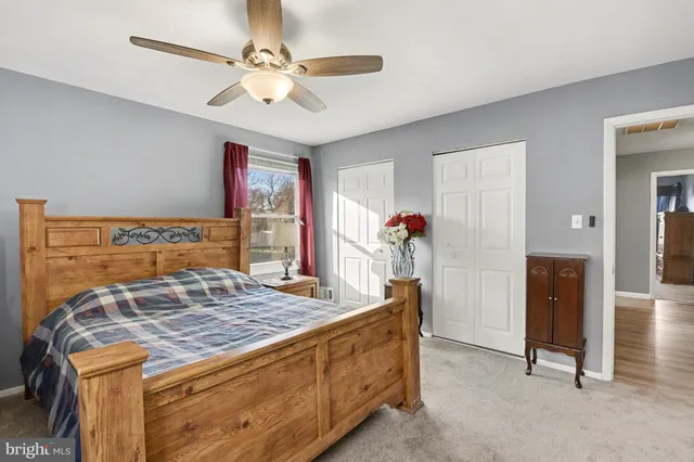 a living room with kitchen island granite countertop furniture and a ceiling fan
